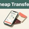 A smartphone showing a transfer app next to a passport on a table.