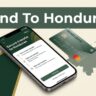 A smartphone with a financial transfer app next to a bank card and map.