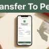 A smartphone showing a transfer screen next to a Peruvian bank card on a desk.
