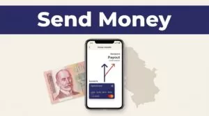Smartphone showing a money transfer beside a Serbian dinar note and map.
