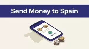 A smartphone showing a confirmed euro transfer beside a Spain map and coins.