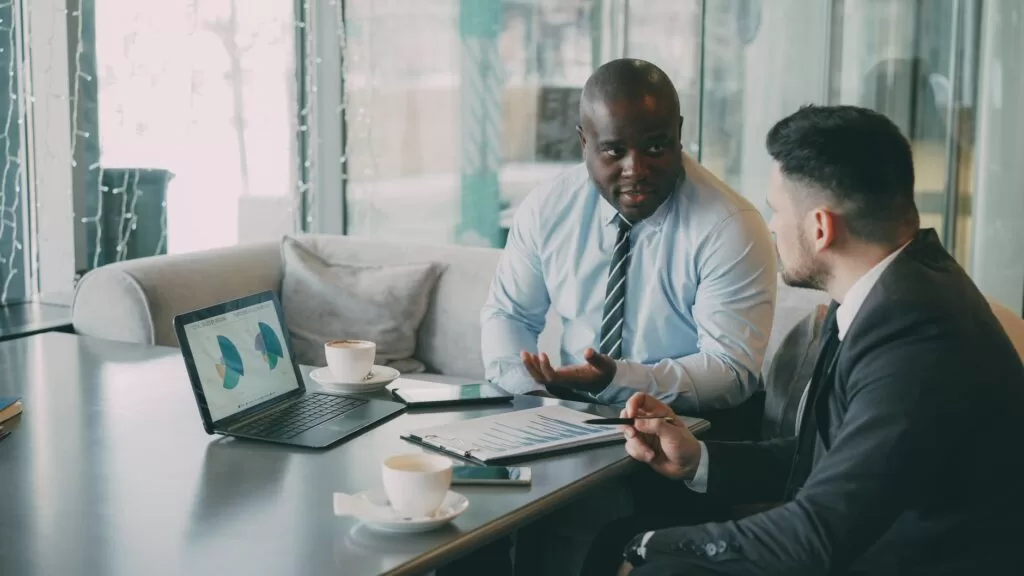 A professional analyzing data charts on a laptop at a modern workspace.